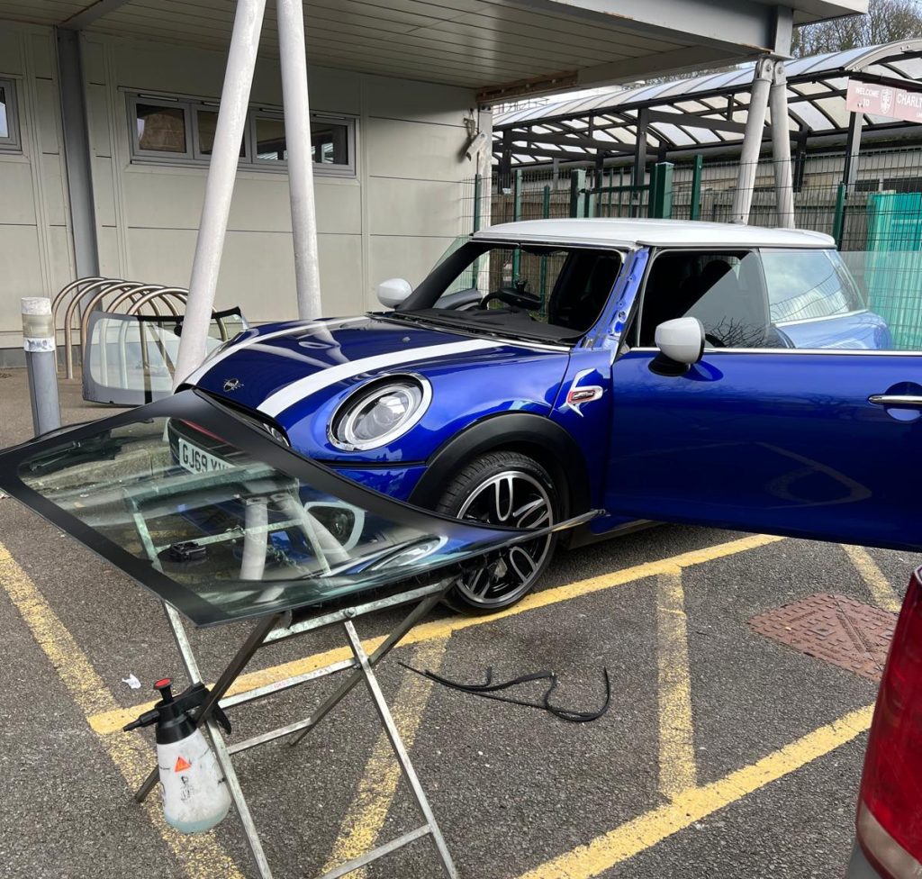 dark blue Mini Cooper with windows removed ready for replacement