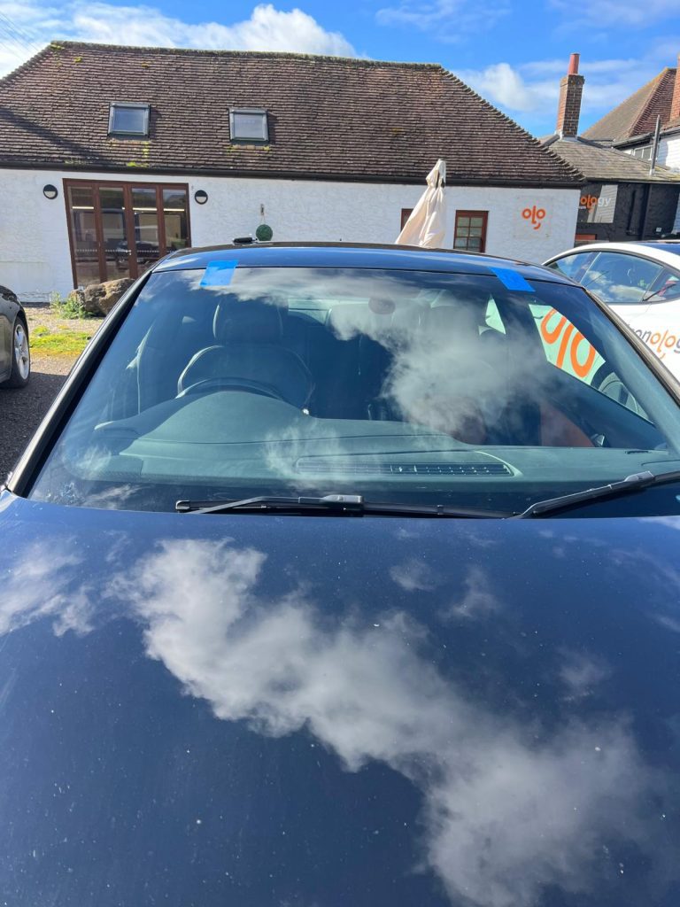 a back car with a brand new windscreen in front of Iconology Ltd in Hythe